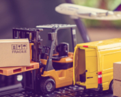 miniature supply chain, van, fork lift, plane on laptop keyboard