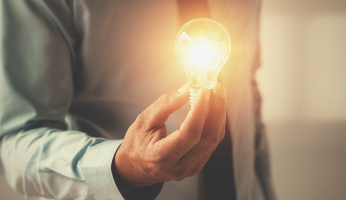 man in suit holding a lightbulb